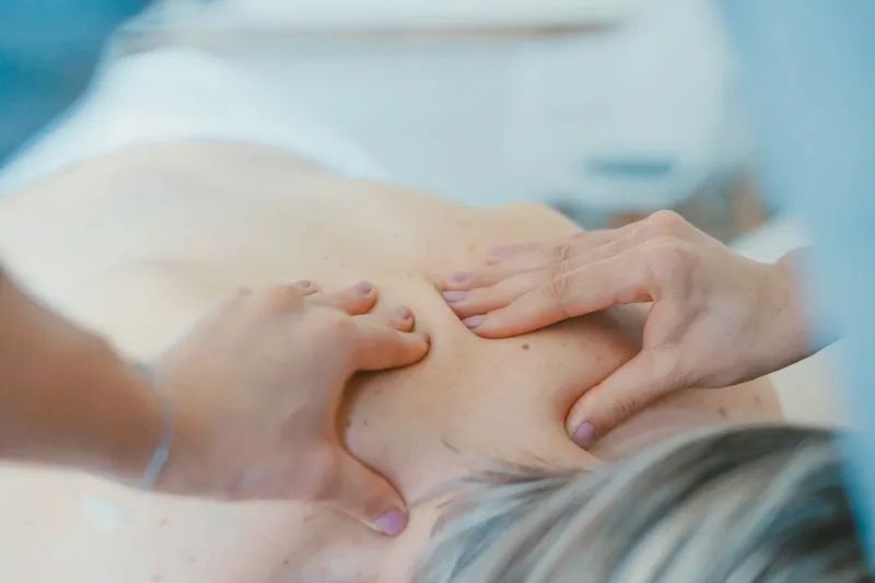 Klassische Massage an Rücken und Schultern bei warmem, natürlichem Licht